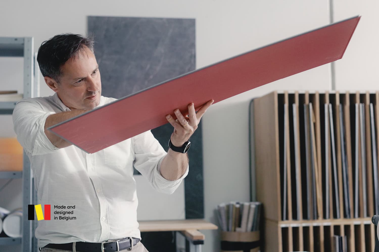 A designer holds a vinyl board and takes a closer look at the design.